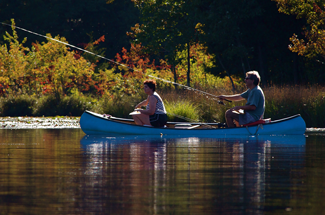 Two people fishing in a canoe at Lake Lenape